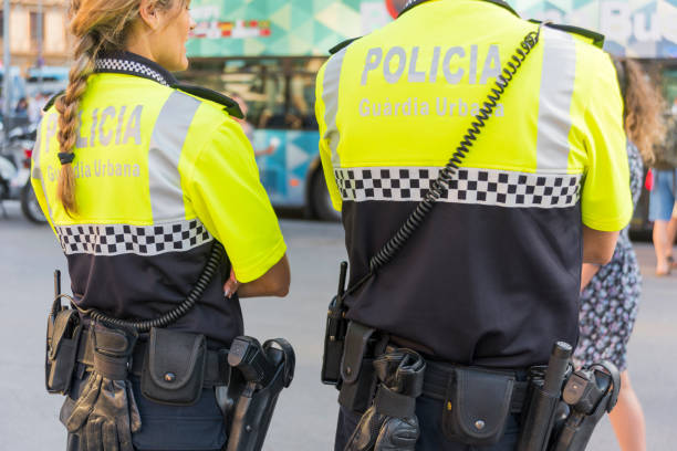 Policeman and Policewoman in Barcelona, Spain 'Barcelona, Spain- jun 1, 2017: Policeman and Policewoman standing on the street in Barcelona, Spain, observing people and doing their job police policewoman women spain stock pictures, royalty-free photos & images