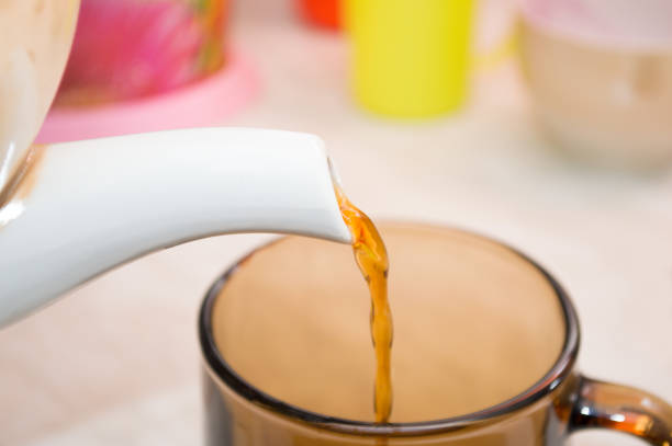 istock pouring tea into cup of tea 800477014