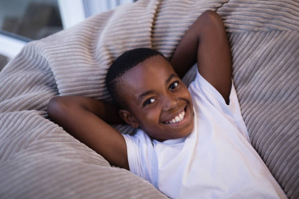 istock Smiling boy resting on couch at home 800477060