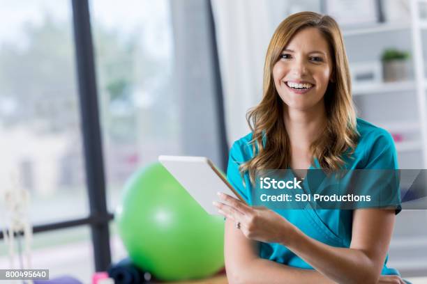Portrait Of Beautiful Physical Therapist Stock Photo - Download Image Now - Physical Therapist, Physical Therapy, Digital Tablet