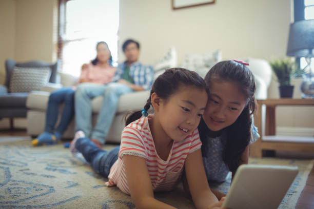 siblings using digital tablet in living room - father digital tablet asian ethnicity daughter imagens e fotografias de stock