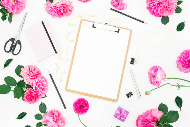 istock Styled wedding workspace with clipboard, notebook, pink roses, ranunculus and accessories on white background. Flat lay, top view. 800501174