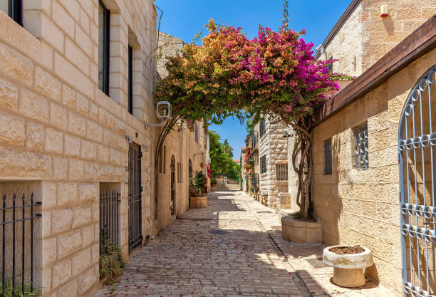 Narrow street of Yemin Moshe district in Jerusalem. Narrow cobblestone street among stone houses in Yemin Moshe neighborhood in Jerusalem, Israel. jerusalem stock pictures, royalty-free photos & images