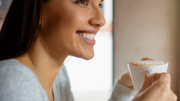istock Smiiling woman enjoying cappucino 800507860