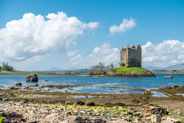 canoes gathering at the historic castle stalker in argyll - loch rowboat lake landscape imagens e fotografias de stock