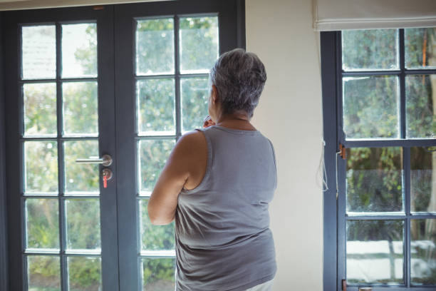 istock Thoughtful senior woman looking through window in bed room 800527710