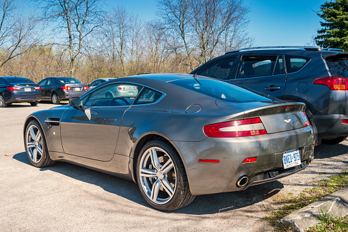 A gray colored Aston Martin V8 Vantage Coupe luxury sports car parked in a parking lot in Hamilton, Ontario.