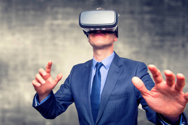 istock Businessman in a suit wearing Virtual Reality Goggles isolated on grey background 800723432