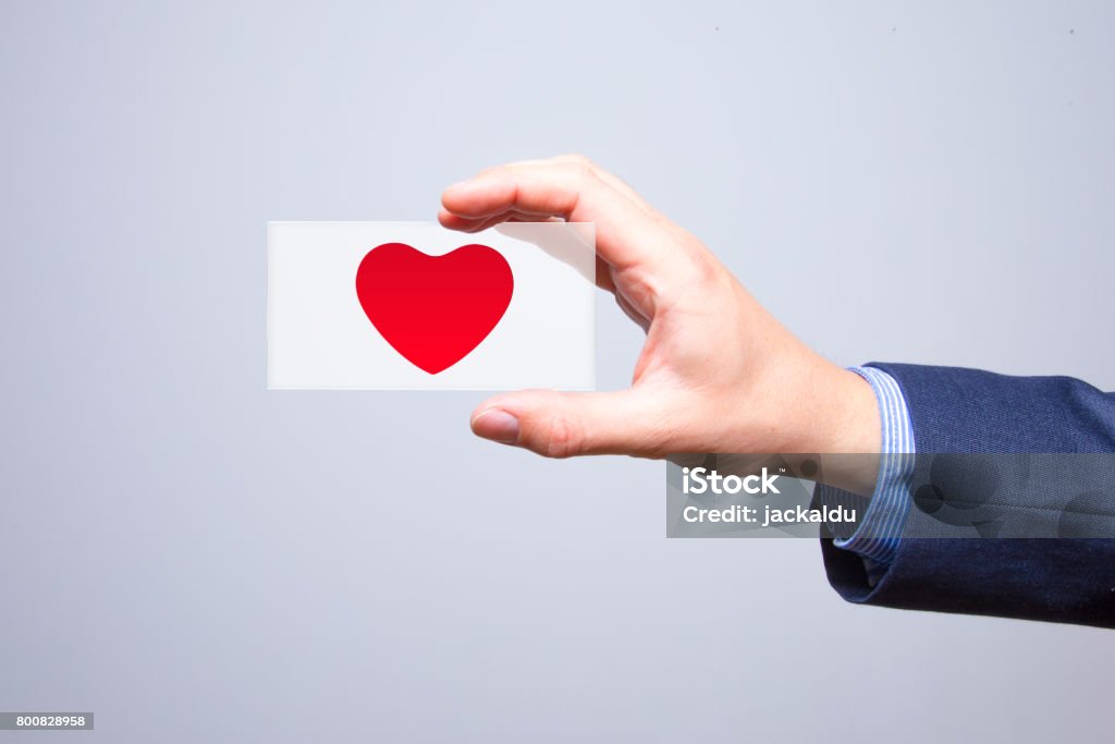 Businessman holding a red heart in his hand - crm - service mind Customer Stock Photo