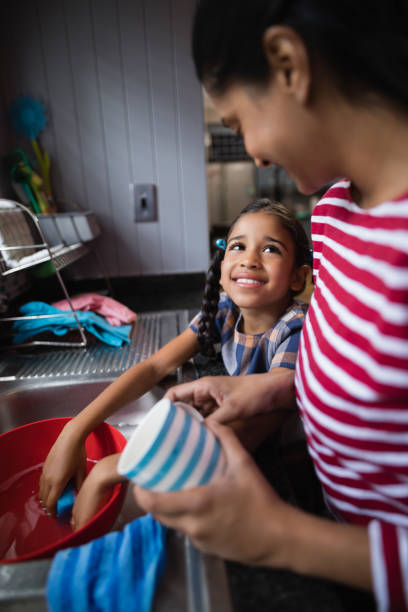 istock Cute smiling girl helping her mother in kitchen 800843096