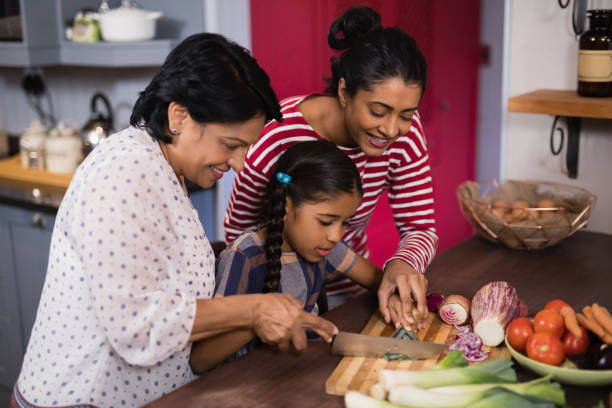 istock Multi-generation family preparing food together in kitchen 800845616