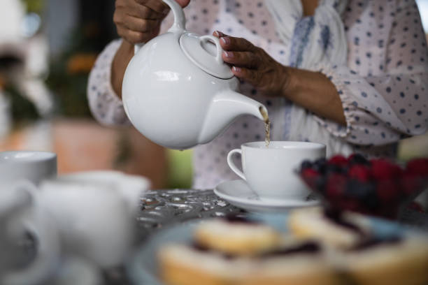 istock Mid section of woman pouring tea in cup 800846106