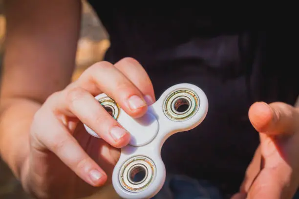 Photo of Young girl play with fidget spinner