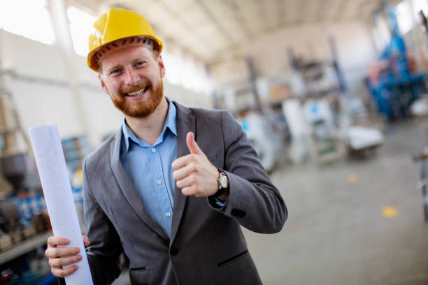 istock Young engineer in factory wearing yellow helmet 800860442