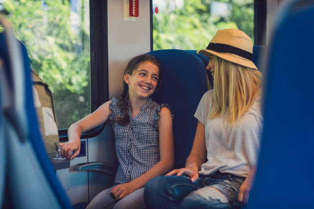 istock Mother and daughter traveling by train together 800866682