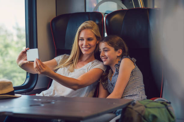 istock Mother and daughter traveling by train together 800871708