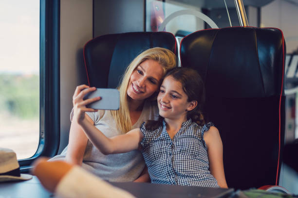 istock Mother and daughter traveling by train together 800871830