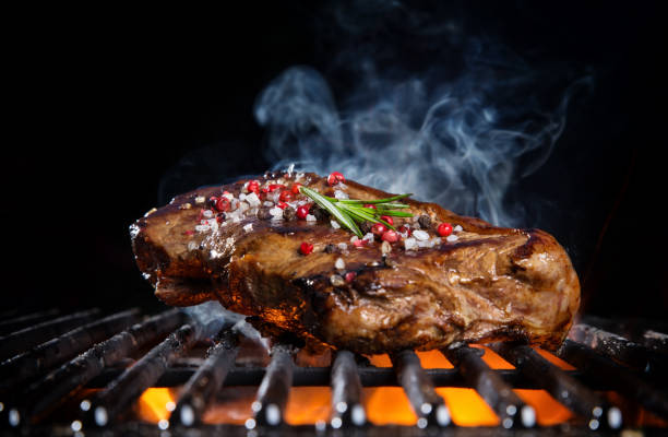 istock Beef steak on the grill grate, flames on background 800874712