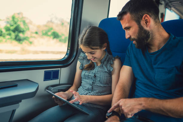 istock Father and daughter traveling by train together. 800881278