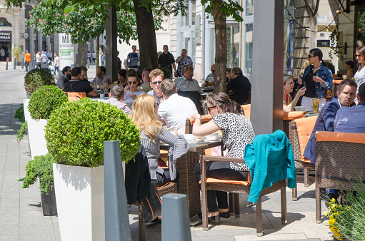 People eating outside on the patio of a restaurant in Budapest during summer day
