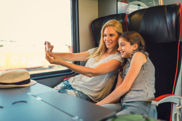istock Mother and daughter traveling by train together 800886772