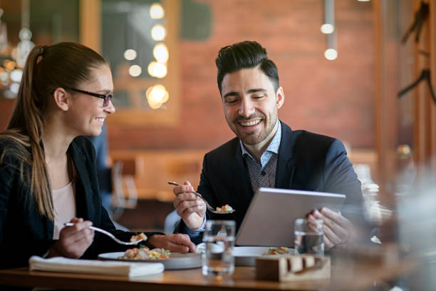 Businesspeople Having Meeting and Lunch In A Restaurant Businesspeople Having Meeting and Lunch In A Restaurant business lunch stock pictures, royalty-free photos & images