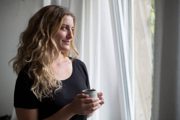 istock Woman Looking Out with Coffee 800917368