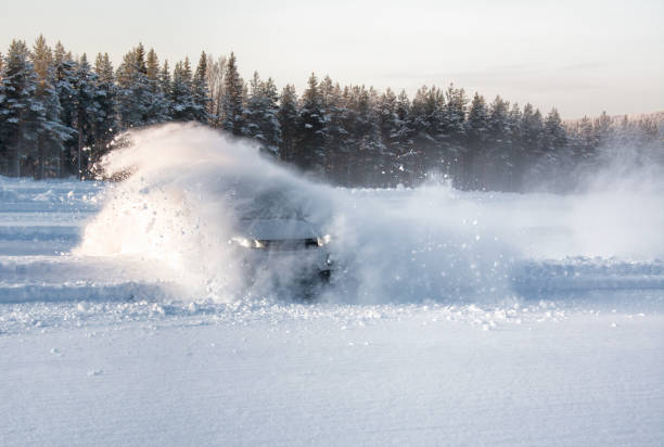 un veicolo che scivola nella neve profonda causando un effetto esplosione - skidding foto e immagini stock