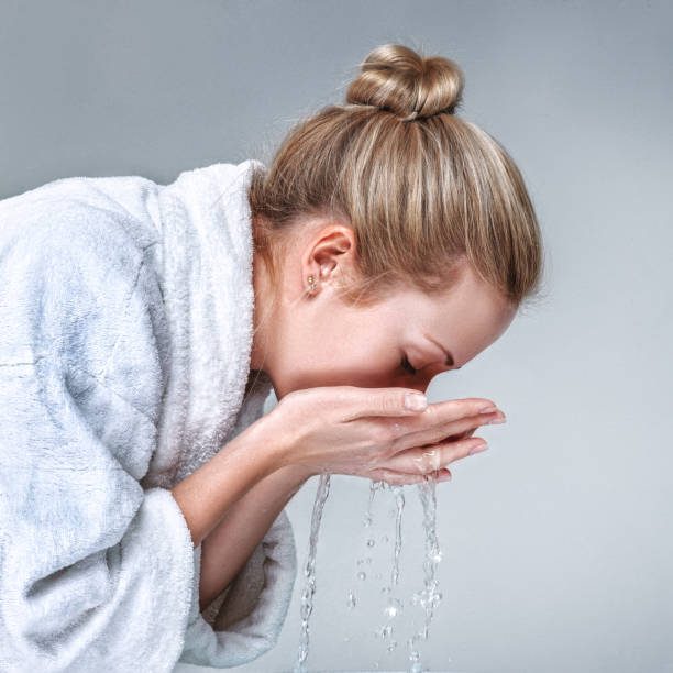 istock Young woman washing her face 800964372