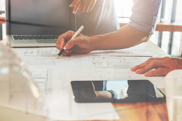 istock Architects engineer discussing at the table with blueprint - Closeup on hands and project print. 800967058