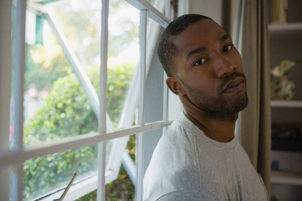 istock Portrait of man leaning on window 800992828