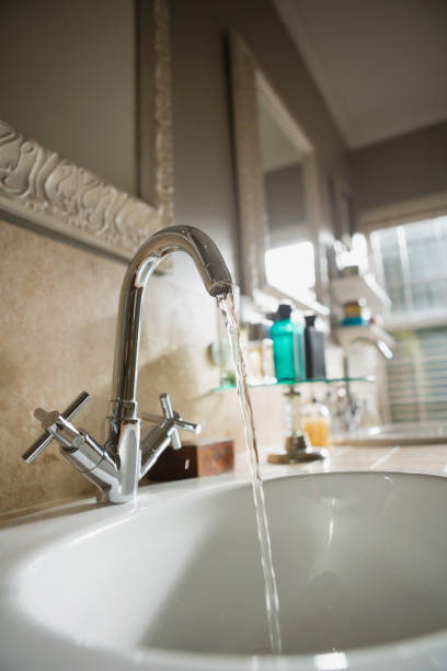 istock Water falling from faucet in bathroom sink 800995116