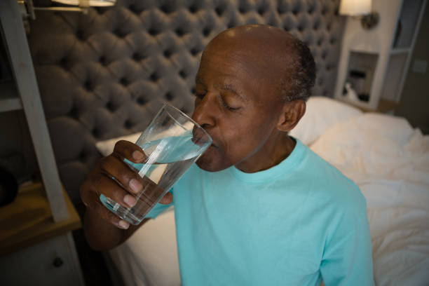 istock Senior man taking medicine while sitting at home 801008622