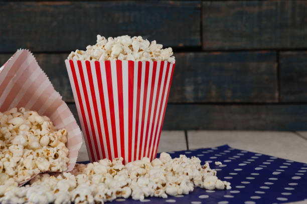 nahaufnahme von verstreuten popcorn auf holztisch - holiday paper spotted close up stock-fotos und bilder