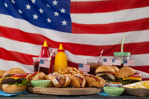 Drinks and snacks arranged on wooden table against American flag