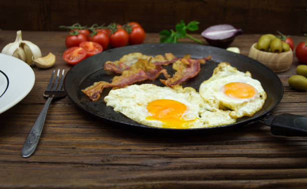 istock Fried eggs and bacon in the frying pan. Gourmet breakfast 801033160