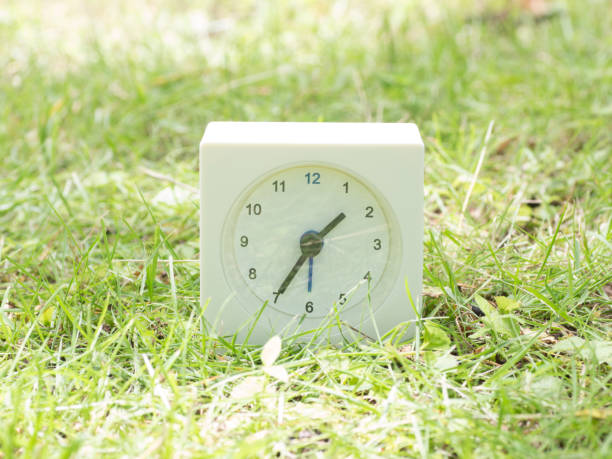 istock White simple clock on lawn yard, 1:35 one thirty five o'clock 801035536