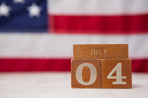 Close-up of date blocks arranged against American flag background