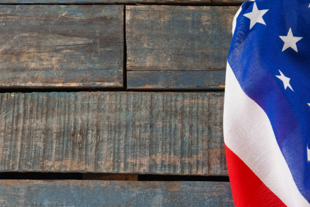 Color image of a wood trunk with an American flag in the background.  Some desaturation and grain added for vintage feel.