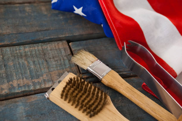 Basting brush and tong with American flag arranged on wooden table