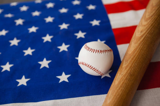 бейсбольная бита и мяч на американском флаге - baseball baseball bat baseballs patriotism стоковые фото и изображения