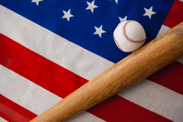 бейсбольная бита и мяч на американском флаге - baseball baseball bat baseballs patriotism стоковые фото и изображения