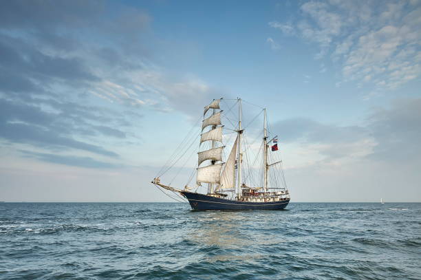 istock Tall Ship under sail with the shore in the background 801056898