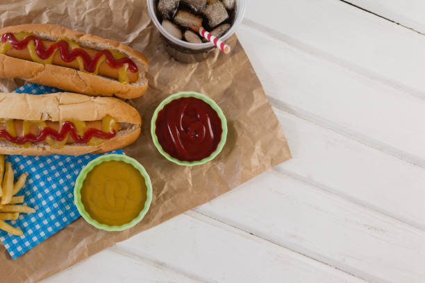istock Hot dog, sauces and cold drink on brown paper 801066460