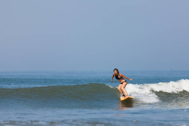 istock Surfer girl riding wave in Bali 801069230