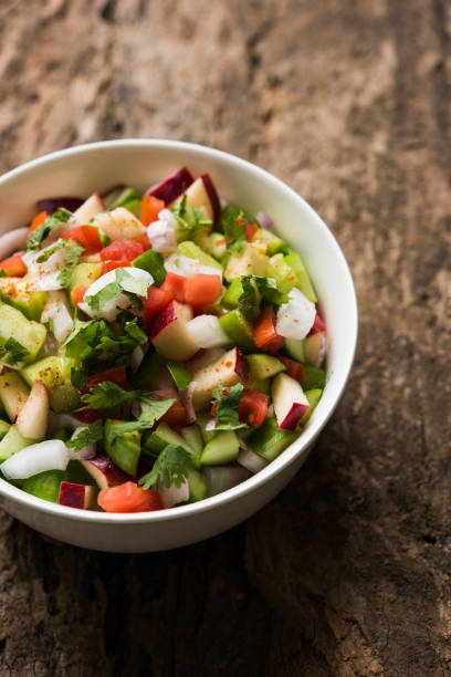 istock Kachumber or indian green salad served in red or white bowl, selective focus 801086778