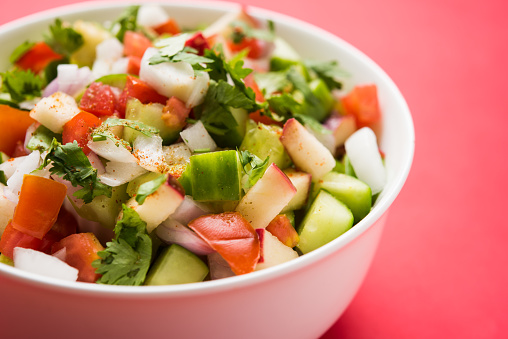 Indian Green Salad also known as Kachumber is a colourful salad dish in Indian cuisine consisting of fresh chopped tomatoes, cucumbers, onions, and sometimes, chili peppers. selective focus