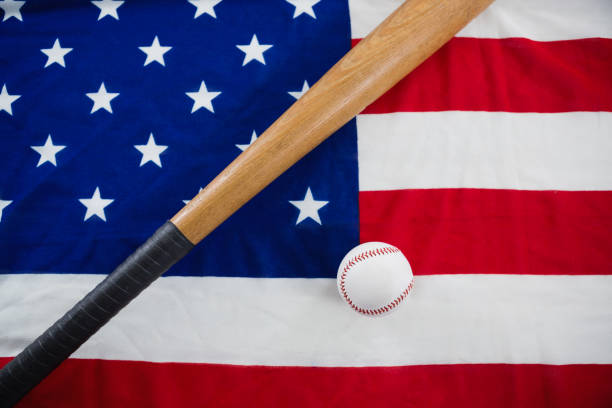 бейсбольная и бейсбольная бита на американском флаге - baseball baseball bat baseballs patriotism стоковые фото и изображения