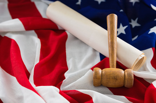 Close-up of gavel and legal documents arranged on American flag