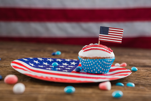 Independence day cupcake on patriotic plate on wooden table